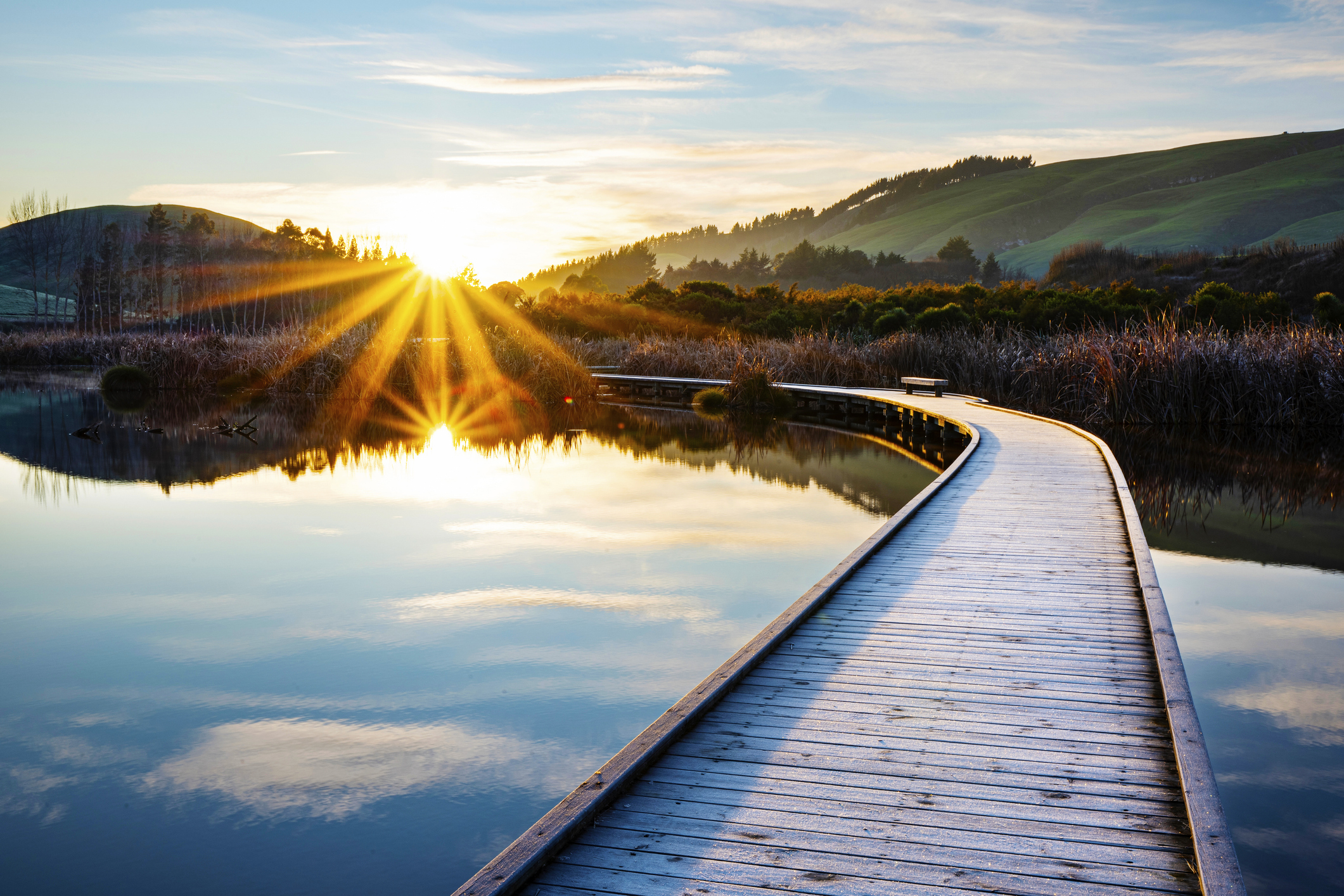 Sunrise over a winding boardwalk